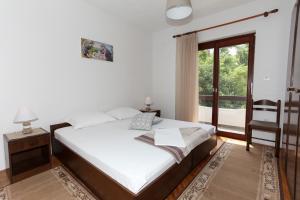a bedroom with a bed and a large window at Apartments Spavalo in Pag
