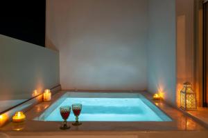 a bath tub with candles and two wine glasses in it at Stardust Suites in Kamari