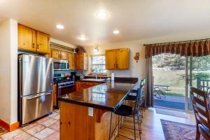 a kitchen with wooden cabinets and a stainless steel refrigerator at Bear Creek Lodge Townhome in Steamboat Springs