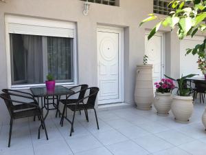 a patio with a table and chairs and plants at VASILEVI STUDIOS in Nea Kallikrateia