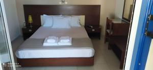 a bedroom with a bed with two towels on it at Panorama Apartments in Methoni