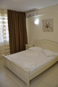 sypialnia z dużym białym łóżkiem w pokoju w obiekcie Hotel Impact G w mieście Costinesti