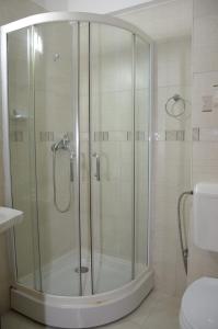 W łazience znajduje się prysznic ze szklanymi drzwiami. w obiekcie Hotel Impact G w mieście Costinesti