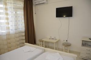 Una habitación con dos camas y un televisor de pantalla plana. en Hotel Impact, en Costinesti