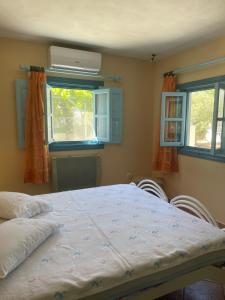 a bedroom with a large bed with two windows at Patmos Villas in Grikos