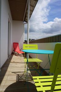 d'une table et de chaises colorées sur un balcon. dans l'établissement Appart Chic & Moderne avec balcon, à La Roche-sur-Yon