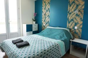 1 dormitorio con cama y pared azul en Appart Chic & Moderne avec balcon en La Roche-sur-Yon