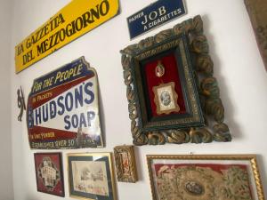 a wall with posters and a clock on it at BRIC à BRAC eclectic rooms in Uggiano la Chiesa