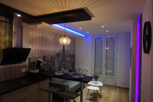 un soggiorno con tavolo e luce viola di Appart Chic & Moderne avec balcon a La Roche-sur-Yon