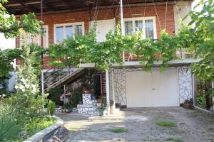 a house with a white garage door and trees at Guest house and Cuisine by Meri Poppins in Dedoplis Tskaro