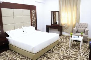 a bedroom with a large bed and a chair at Al Farhan Dumah Al Jandal in Dawmat al Jandal