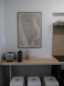 a map on a wall above a shelf with two toilets at Appartement le Flatiron - 4 chambres in Tarbes