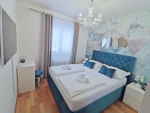 a bedroom with a blue and white bed and a chandelier at Apartment Ivona in Makarska