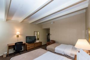 Cette chambre comprend deux lits et une télévision. dans l'établissement Windjammer Lodge, à Ogdensburg