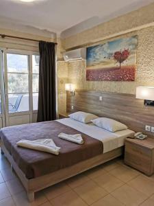 a bedroom with a large bed with two towels on it at Paradise Hotel in Samos