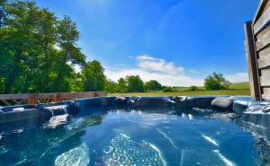 a large plunge pool with blue water in a backyard at Chalets CASABELLA in Casteljaloux