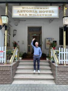 um homem em pé em degraus em frente a um hotel em Astoria Hotel Bad Wildstein em Traben-Trarbach