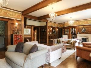 sala de estar con sofás y chimenea en Bearnock Lodge en Inverness