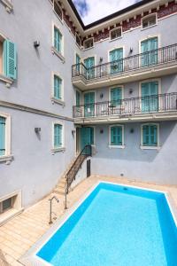 an apartment with a swimming pool in front of a building at Mefuta Hotel in Gardone Riviera