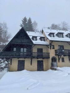 a large house with snow on top of it at Appartement Chalet à 1400m - Station du Mourtis in Boutx