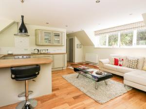 cocina y sala de estar con sofá y mesa en Waterfall Apartment en Inverness