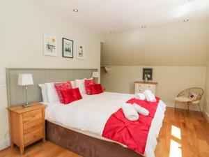 a bedroom with a large bed with red and white pillows at Waterfall Apartment in Inverness