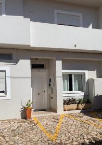 - un bâtiment blanc avec une porte et une fenêtre dans l'établissement Casa da Aldeia - Guest House, à Odiáxere