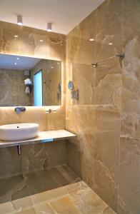 a bathroom with a sink and a mirror at Bella Vista Hotel Studios & Apartments in Parga