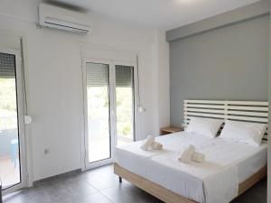 a white bedroom with a large bed with white sheets at VIAL Rooms in Himare