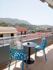 patio z 2 krzesłami i stołem na balkonie w obiekcie VIAL Rooms w mieście Himara
