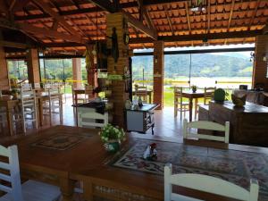 a dining room with a table and chairs in a building at Chalé Represa Recanto Varanda do Sol in Vargem