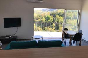 a living room with a couch and a table and a large window at vacances au vert in Baillif