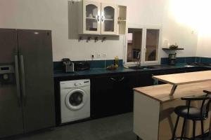 a kitchen with a washing machine in a kitchen at vacances au vert in Baillif