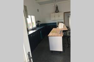a kitchen with black cabinets and a wooden counter top at vacances au vert in Baillif +9 photos