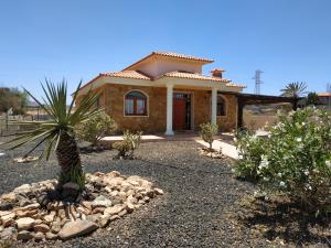 a small house with a palm tree in front of it at Villa Casa Del Sol 3 Bedroom Villa With Private Solar Covered 12m x 6m Pool Minimum Stay 7 Nights Chromecast And WiFi Throughout The Property in Triquivijate