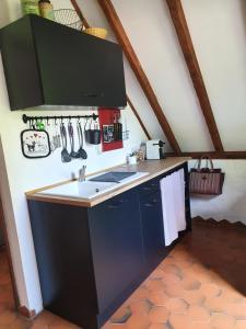 a kitchen with a sink and utensils on the wall at Gîtes sur Le Causse de St CHELS, charme sport et détente in Saint-Chels
