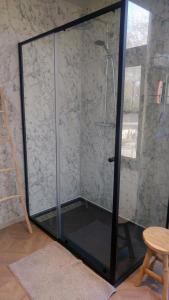 - une cabine de douche en verre avec une porte en verre dans l'établissement B6, à Ursel
