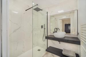 a bathroom with a sink and a glass shower at Disney and Paris * Netflix * Parking * 6 pers in Chessy +10 photos