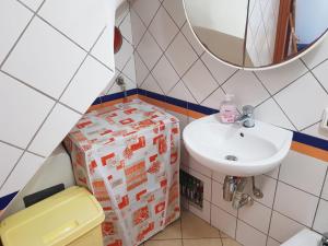 a bathroom with a sink and a gift box at Casa Vacanze Maniscalco Sciacca in Sciacca