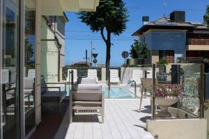 a patio with chairs and a swimming pool at Atmosphere Suite Hotel in Rimini