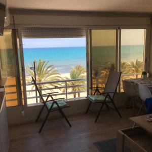 um quarto com cadeiras e vista para o oceano em Frente al mar, a 10 metros de la playa, vistas increíbles del mar, reformado 2021 !!! em El Campello