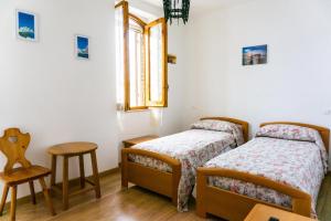 a bedroom with two beds and a chair and a window at Il Castello Holiday Home in San Vito Chietino