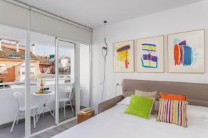 sypialnia z łóżkiem, stołem i krzesłami w obiekcie Pop Art, Apartamentos de diseño en Arenal w Sewilli