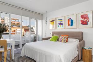 sypialnia z łóżkiem i jadalnia ze stołem w obiekcie Pop Art, Apartamentos de diseño en Arenal w Sewilli