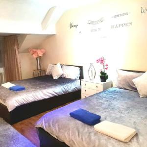 two beds in a bedroom with blue towels on them at Gabriel Guesthouse in Rhyl