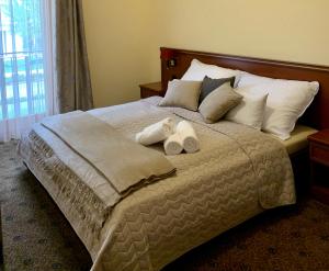 a bedroom with a bed with two towels on it at A01 Sétány-Silverine Apartmanház-Őrzött parkolóval in Balatonfüred