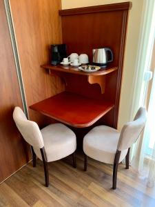 A01 Sétány-Silverine Apartmanház-Őrzött parkolóval في بالاتونفوريد: طاولة صغيرة و كرسيين في الغرفة