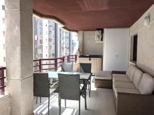 einen Balkon mit einem Tisch, Stühlen und einem Sofa in der Unterkunft Cabeho Beach Homes in Calpe