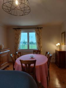 d'une salle à manger avec une table, des chaises et une fenêtre. dans l'établissement TY ANN maison avec jardin clos de mur, à proximité des commerces et à 3km des plages, à Penvénan