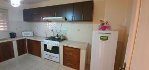 a kitchen with a white stove and a refrigerator at Departamento Jireh in Tarija +5 photos